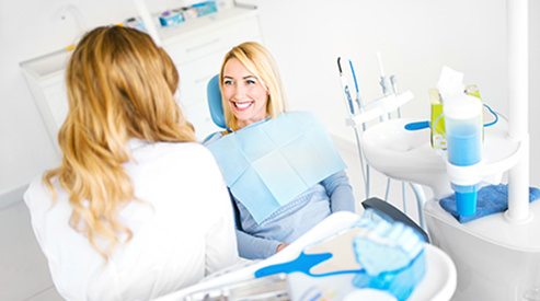 Dentist talking with patient in dental chair